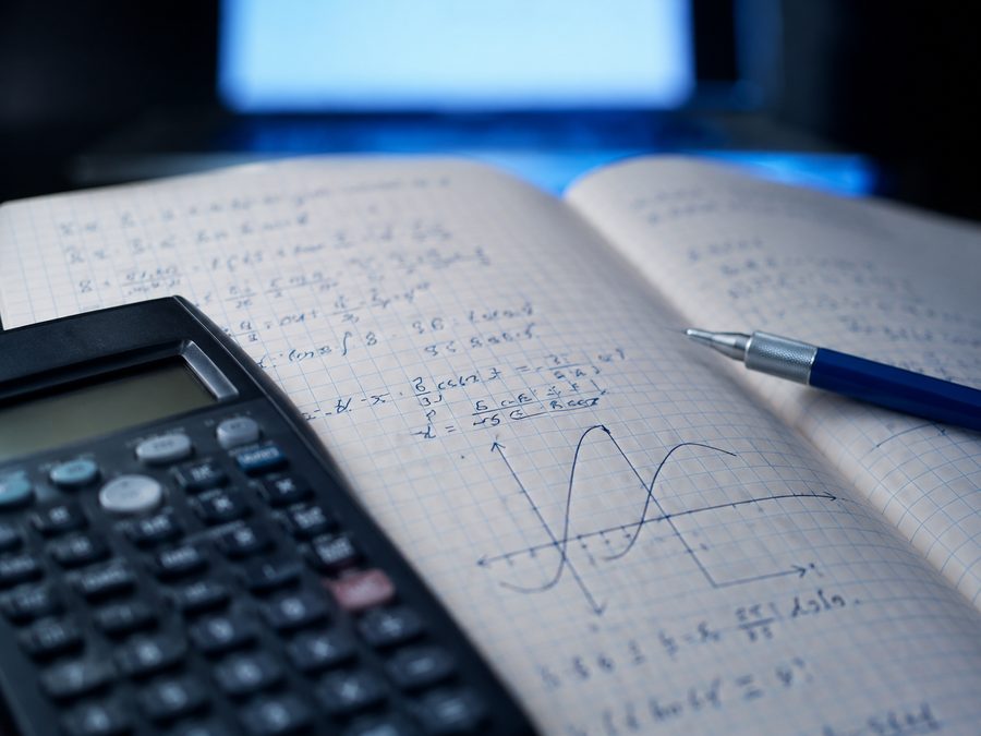 Cuaderno con desarrollo matemático y calculadora científica